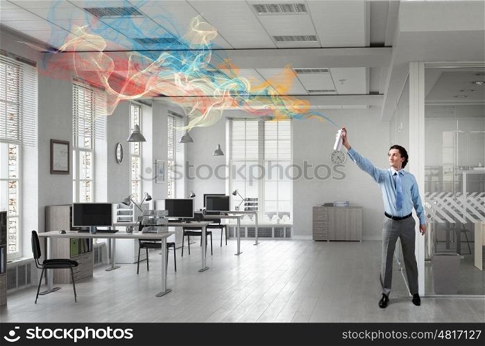 Businessman with aerosol can. Businessman in office interior spraying paint from aerosol