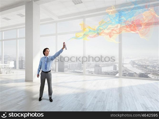 Businessman with aerosol can. Concept of creativity with businessman in office spraying paint from balloon