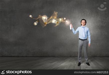 Businessman with aerosol can. Concept of creativity with businessman spraying light bulbs from balloon