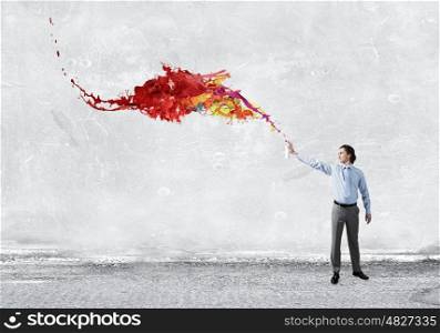 Businessman with aerosol can. Concept of creativity with businessman spraying paint from balloon