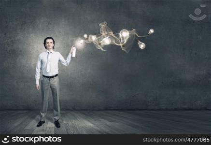 Businessman with aerosol can. Young businessman spraying glass bulbs from aerosol can as symbol of creative ideas