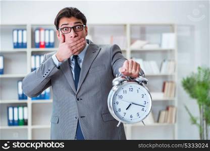 Businessman with alarm clock in the office