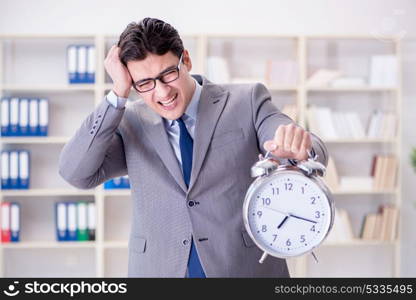 Businessman with alarm clock in the office