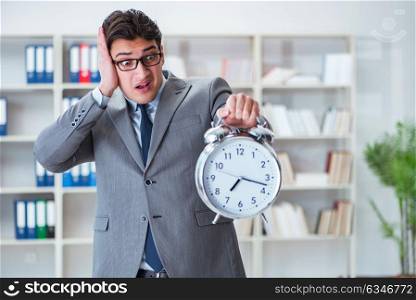 Businessman with alarm clock in the office