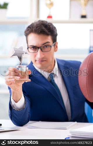 Businessman with american football in office