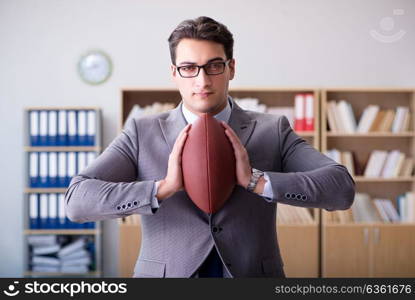 Businessman with american football in office