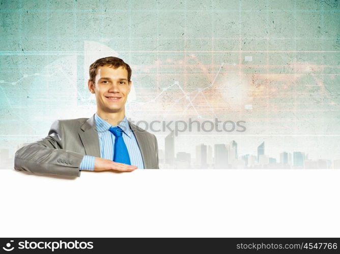 Businessman with blank banner. Businessman with blank banner standing against urban scenic. Place for text