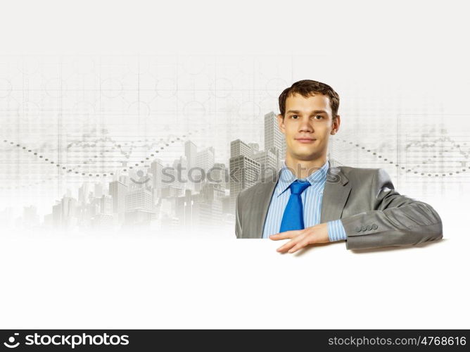 Businessman with blank banner. Businessman with blank banner standing against urban scenic. Place for text