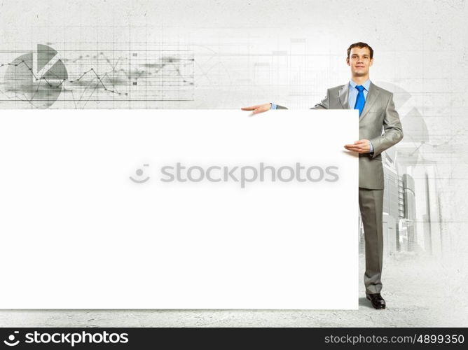 Businessman with blank banner. Businessman with blank banner standing against urban scenic. Place for text