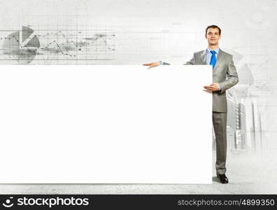 Businessman with blank banner. Businessman with blank banner standing against urban scenic. Place for text