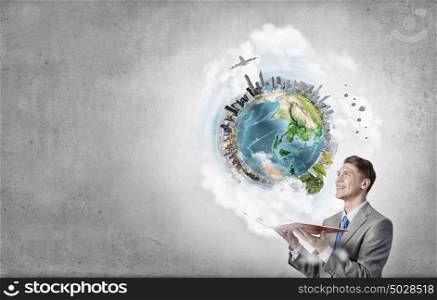Businessman with book. Young businessman with opened book in hands. Elements of this image are furnished by NASA