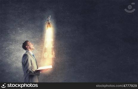 Businessman with book. Young shocked businessman with book in hands