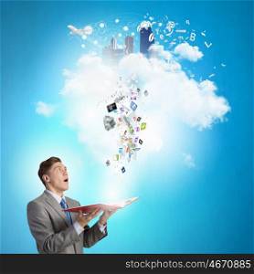 Businessman with book. Young shocked businessman with book in hands and icons flying out