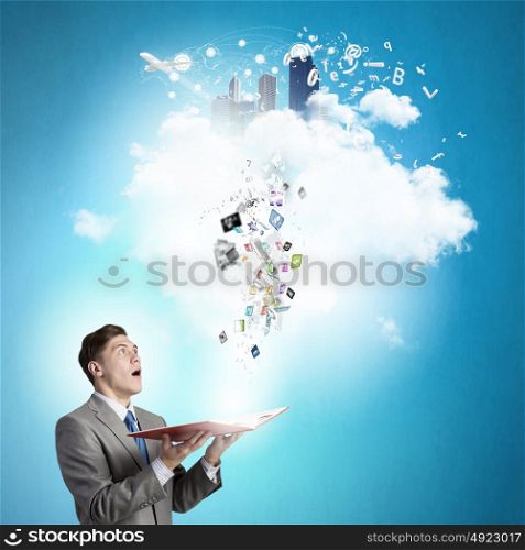Businessman with book. Young shocked businessman with book in hands and icons flying out