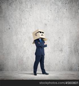 Businessman with box on head. Businessman wearing carton box with smileys on head