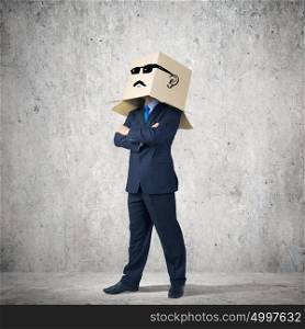 Businessman with box on head. Businessman wearing carton box with smileys on head