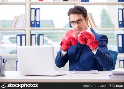 Businessman with boxing gloves angry in office