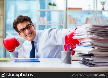 Businessman with boxing gloves in the office. The businessman with boxing gloves in the office