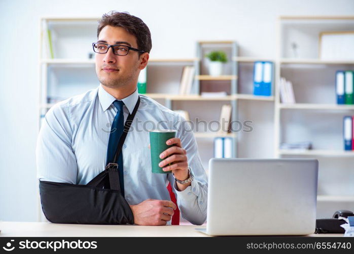 Businessman with broken arm working in office