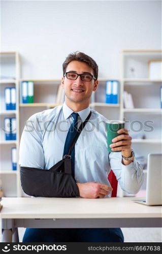 Businessman with broken arm working in office