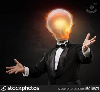 Businessman with burning lamp head on black background. Welcoming gesture