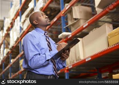 Businessman With Clipboard In Warehouse