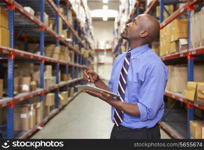 Businessman With Clipboard In Warehouse