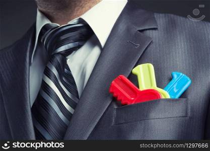 Businessman with colorful toy keys in suit pocket