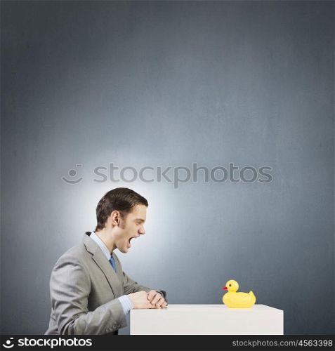 Businessman with duck. Funny businessman with yellow rubber duck toy