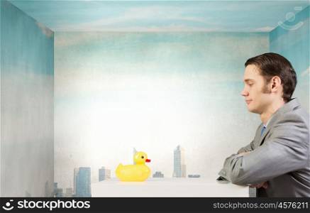 Businessman with duck. Funny businessman with yellow rubber duck toy