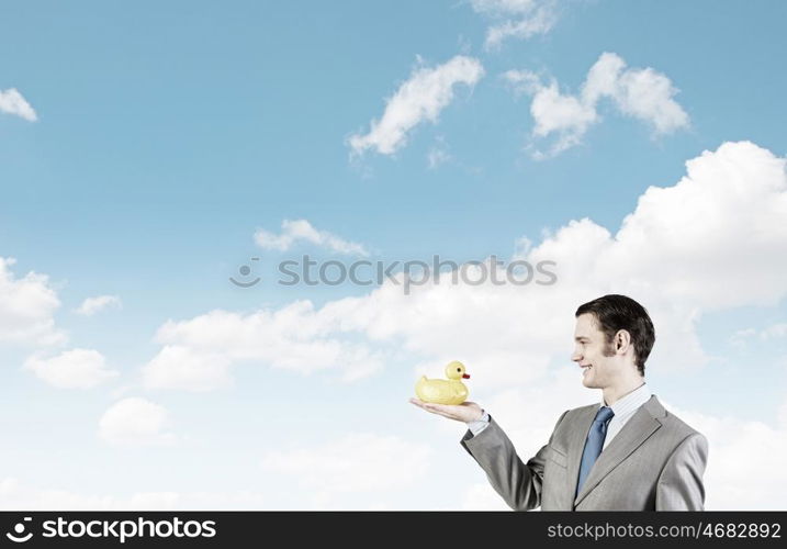 Businessman with duck. Funny businessman with yellow rubber duck toy