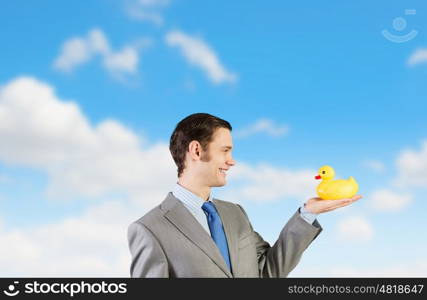 Businessman with duck. Funny businessman with yellow rubber duck toy