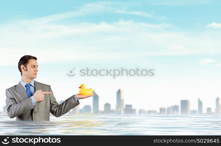 Businessman with duck. Funny businessman with yellow rubber duck toy