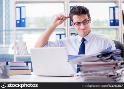 Businessman with excessive work paperwork working in office