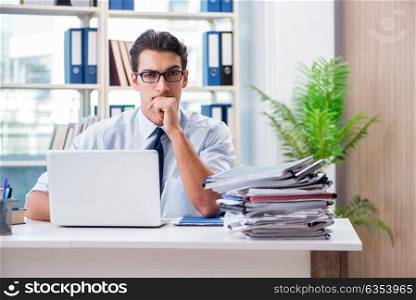 Businessman with excessive work paperwork working in office