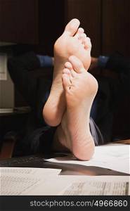 Businessman with feet up on desk