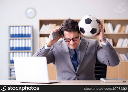 Businessman with football ball in office