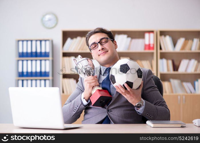 Businessman with football ball in office