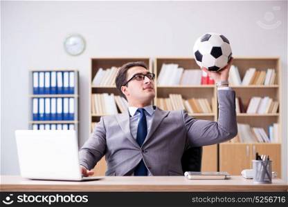 Businessman with football ball in office