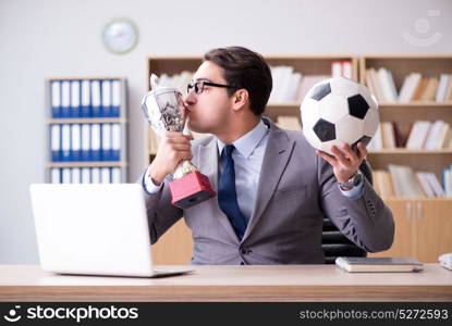 Businessman with football ball in office