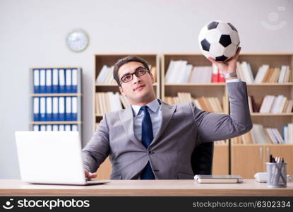 Businessman with football ball in office