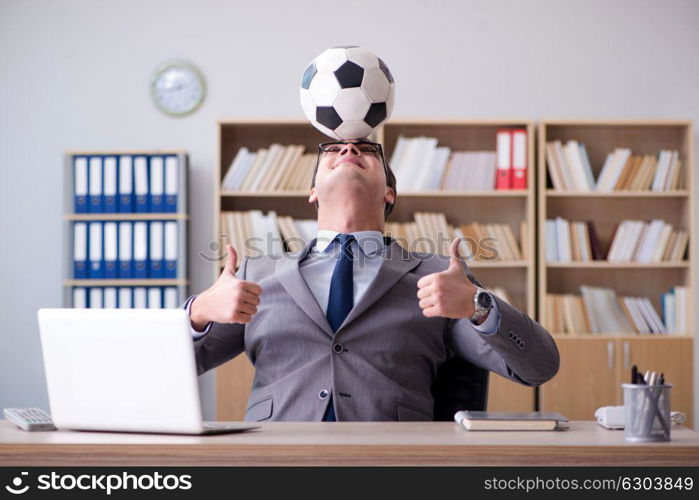 Businessman with football ball in office