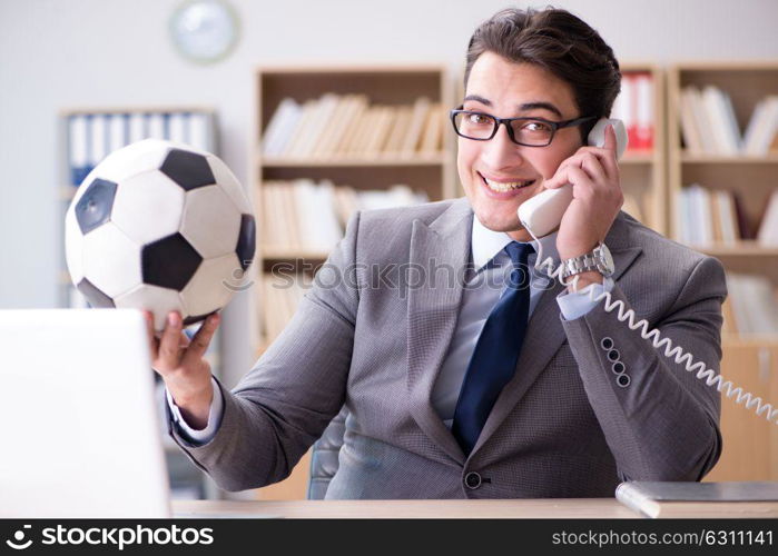 Businessman with football ball in office