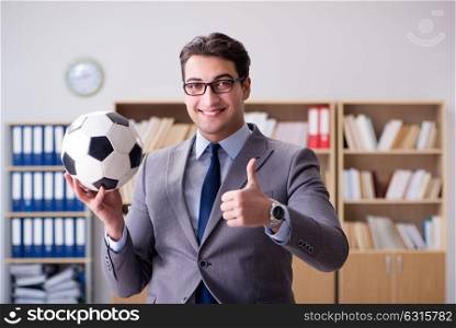 Businessman with football ball in office