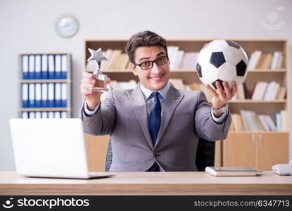 Businessman with football ball in office