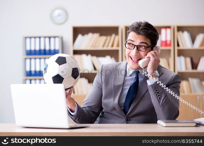 Businessman with football ball in office