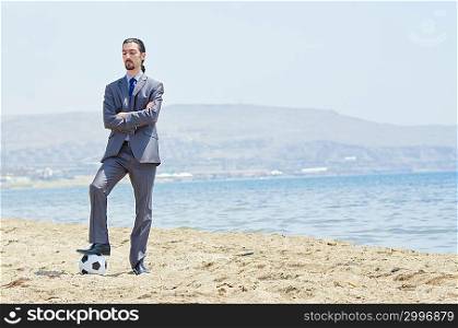 Businessman with football on beach