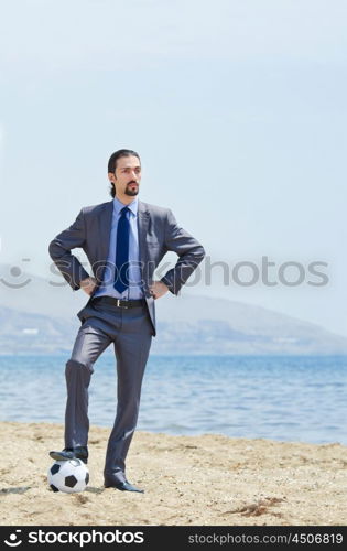 Businessman with football on beach