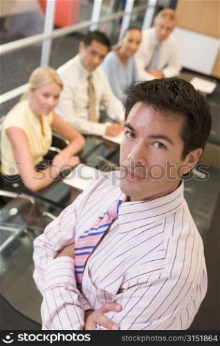 Businessman with four businesspeople at boardroom table in background