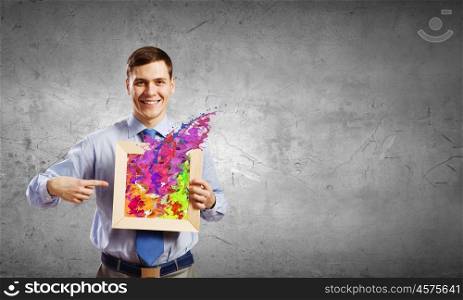 Businessman with frame. Unrecognizable businessman holding wooden frame with splashes